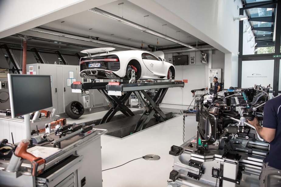 برای این که مهندسان بتوانند زیر خودرو کار کنند، بوگاتی شیرون این چنین روی بالابر قرار می‌گیرد 