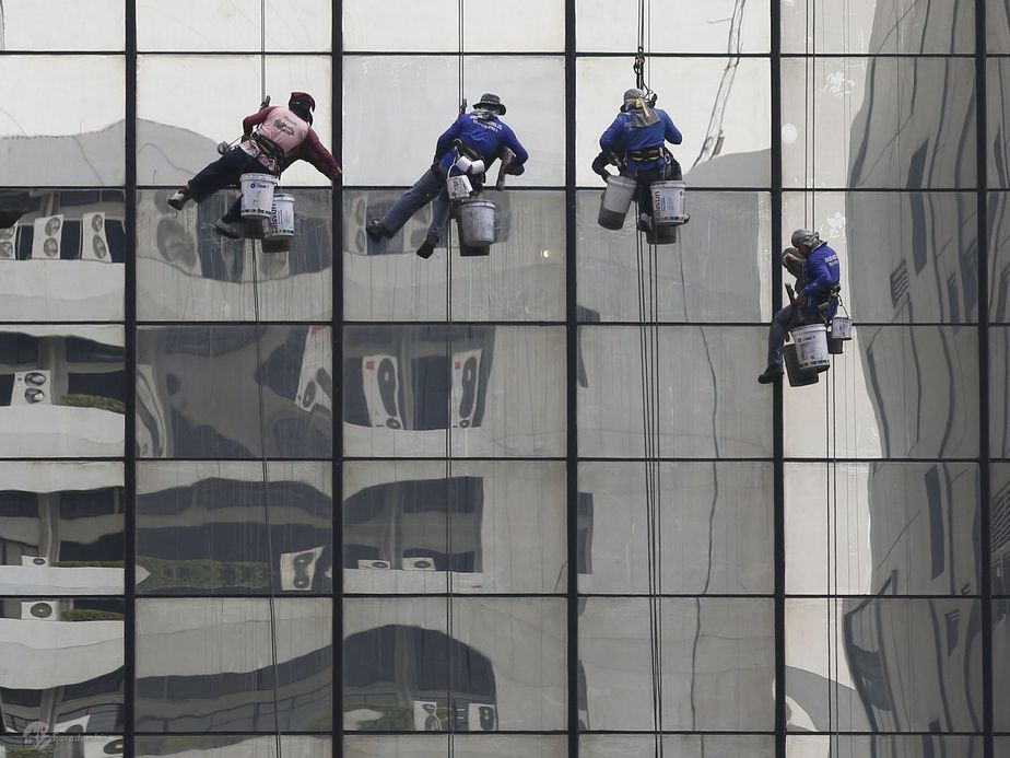 مردان نظافتچی در حال تمیزکردن شیشه‌ها.(تایلند)