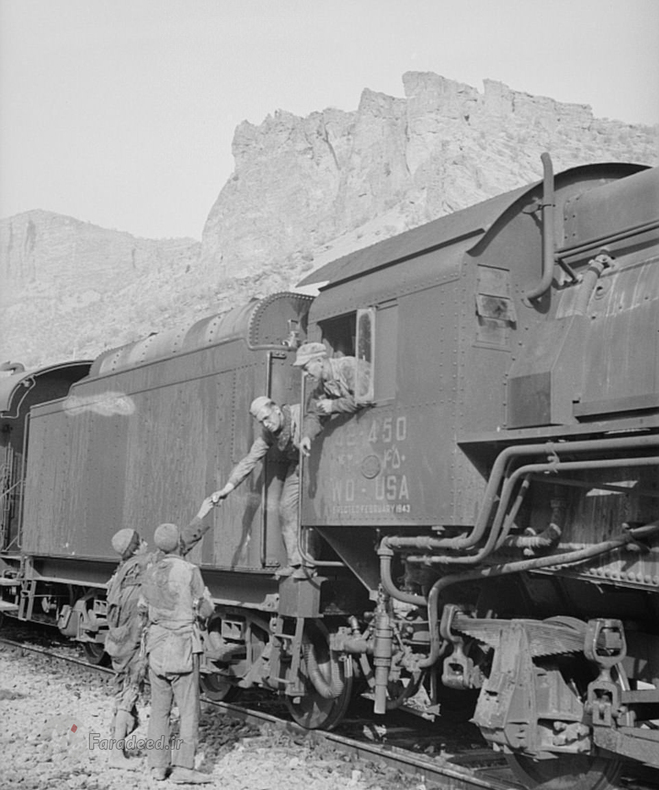 دو امریکایی سوار بر قطار پیش از حرکت به سمت شوروی به دو مرد گرسنه و قحطی زده کمک می کنند.