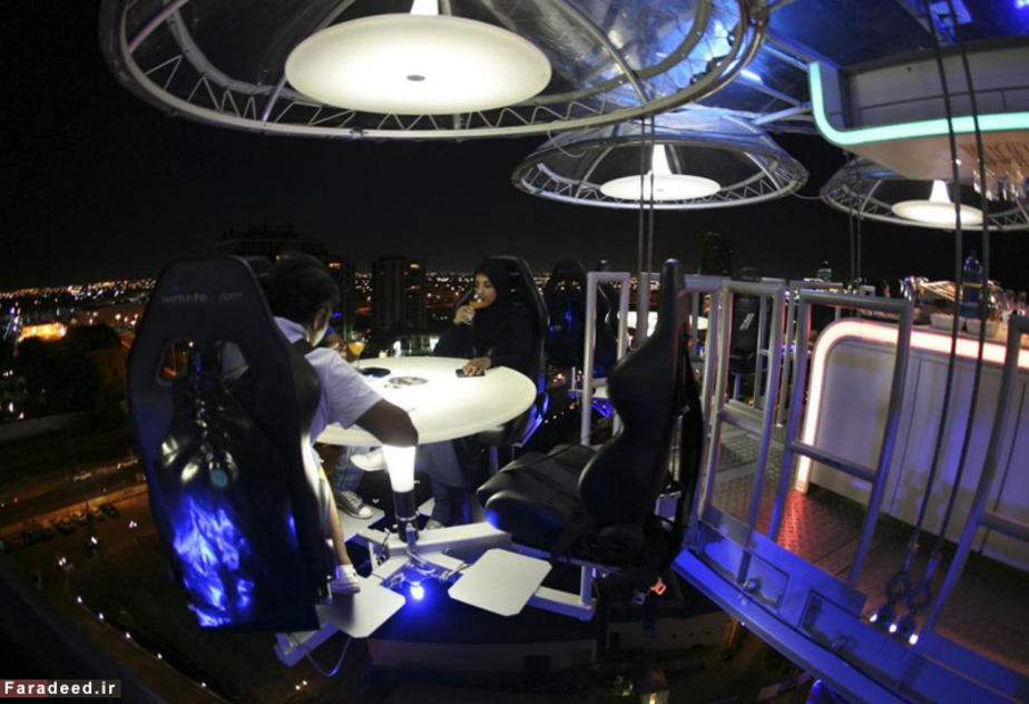 زن عرب و همسرش در رستوران معلق در جده؛ این رستوران در جده با کمک جرثقیل میزهای غذا و میهمانان را در فضایی معلق میان زمین و آسمان نگه میدارد.