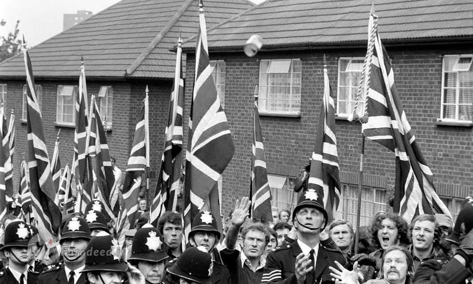 افسر پلیس در حال گرفتن یک شیشه که به سمت هواداران جبهه ملی پرتاب شده است.