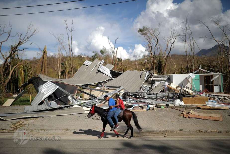جایویا، پورتوریکو| دو شهروند در حال گذر با اسب از کنار ساختمان‌های ویران شده توسط طوفان مهیب ماریا