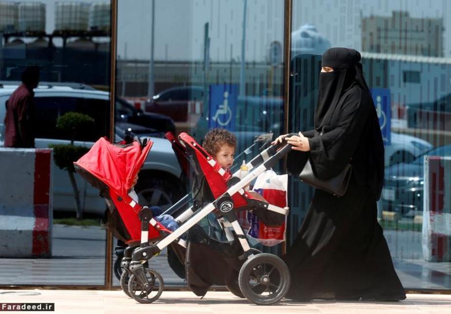 یک زن و دو فرزندش در حال عبور از خیابان در ریاض