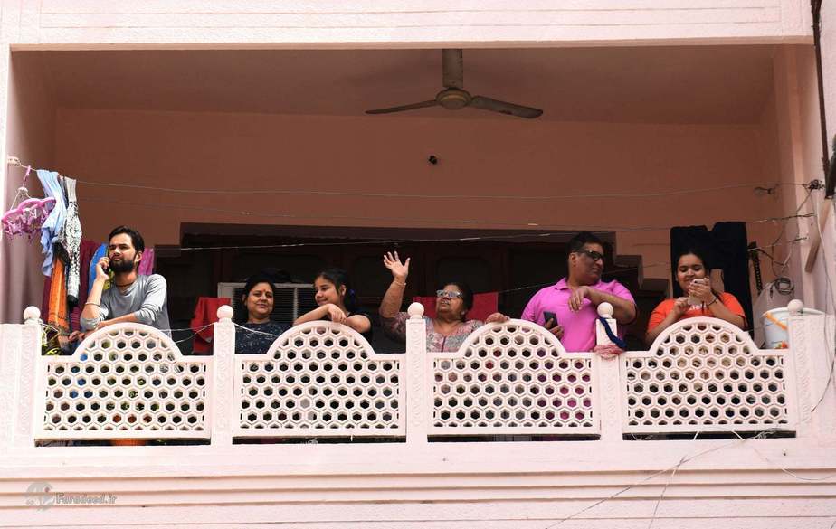 اعضای خانوادهای در بالکن خانهشان. عکاس: Narinder Nanu/AFP