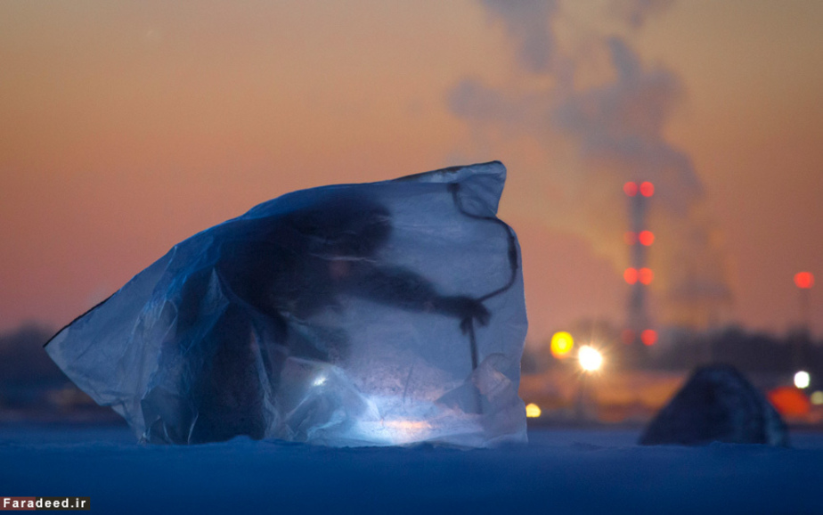 ماهیگیری مردی در محافظ پلاستیکی خلیج فنلاند در غرب سن پترزبورگ